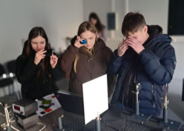 Школярі розглядають спектральні фільтри в лабораторії кафедри оптики